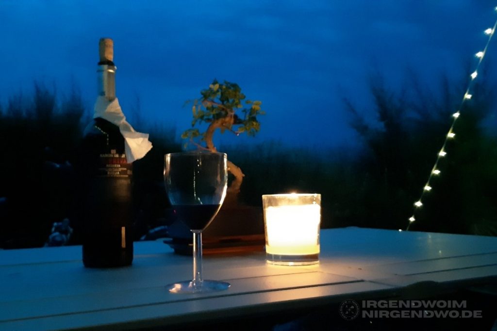 Camping in Kroatien. Lichterkette, Kerze, Wein und Bonsai