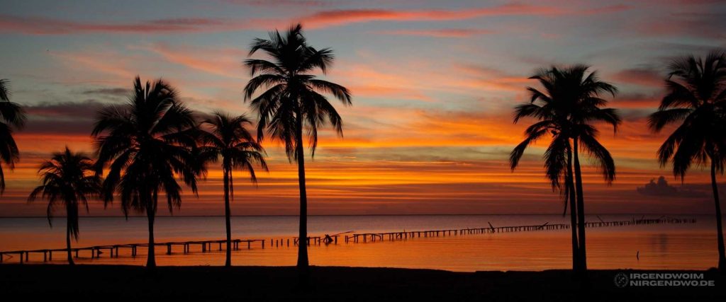 Strand, Palmen und Sonnenuntergang auf der Isla de la Juventud, einer Nebeninsel von Kuba.