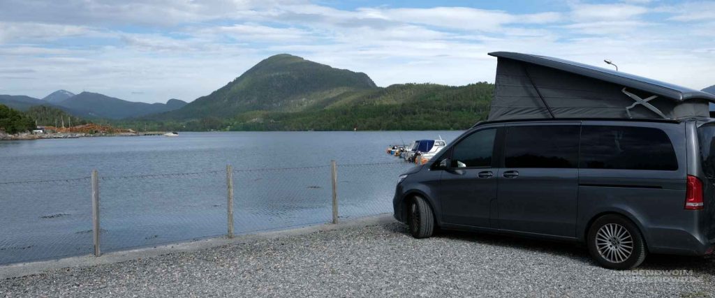Mercedes Marco Polo Camper mit aufgestelltem Dach an einem Fjord in Norwegen.