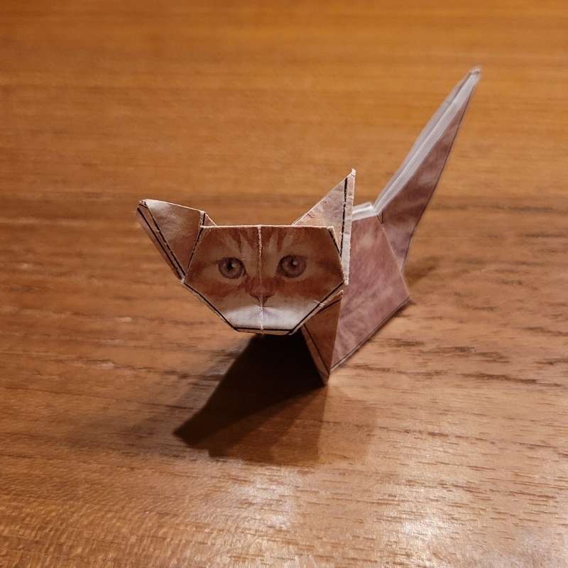 Eine Origami-Katze sitzt auf dem Tisch.