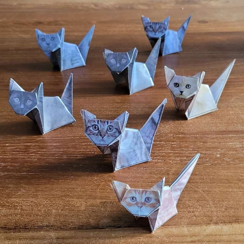 Viele Origami-Katzen sitzen auf dem Tisch.